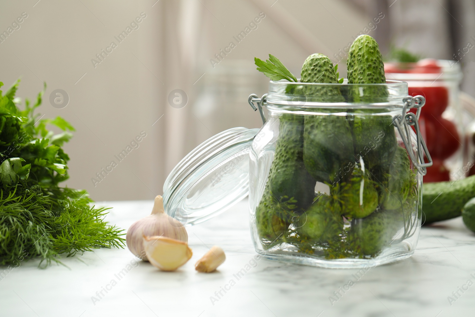 Photo of Pickling jar with fresh cucumbers on white marble table