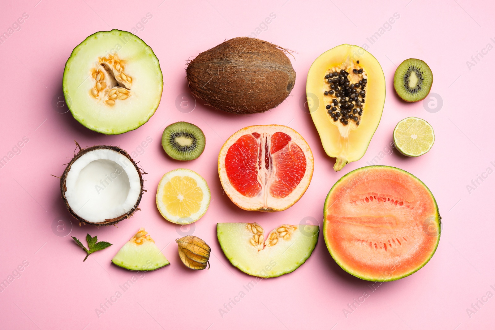 Photo of Flat lay composition with tasty melon and fresh tropical fruits on pink background