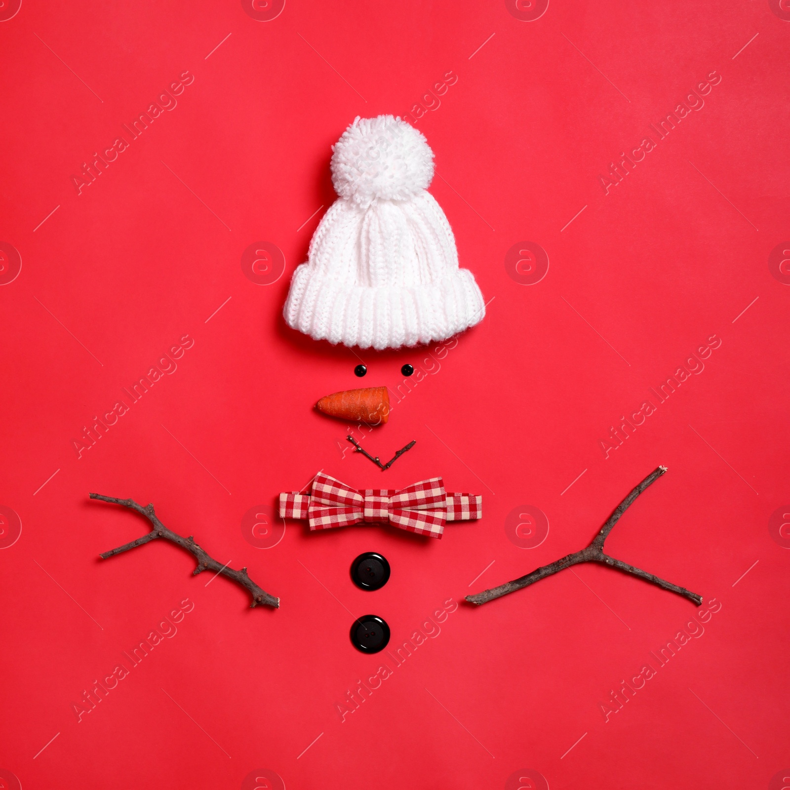 Photo of Funny snowman made with different elements on red background, flat lay