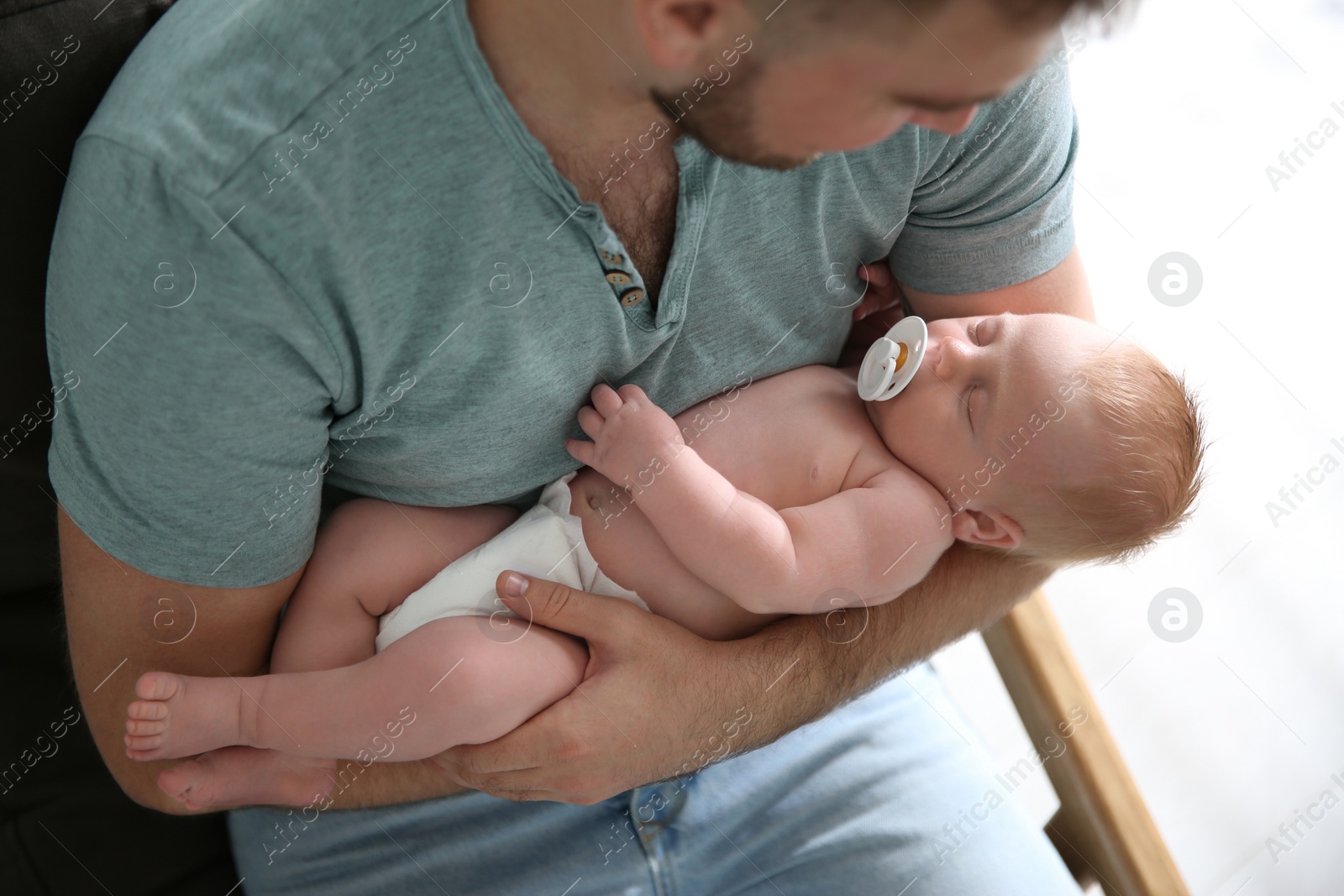 Photo of Father with his newborn son at home, closeup