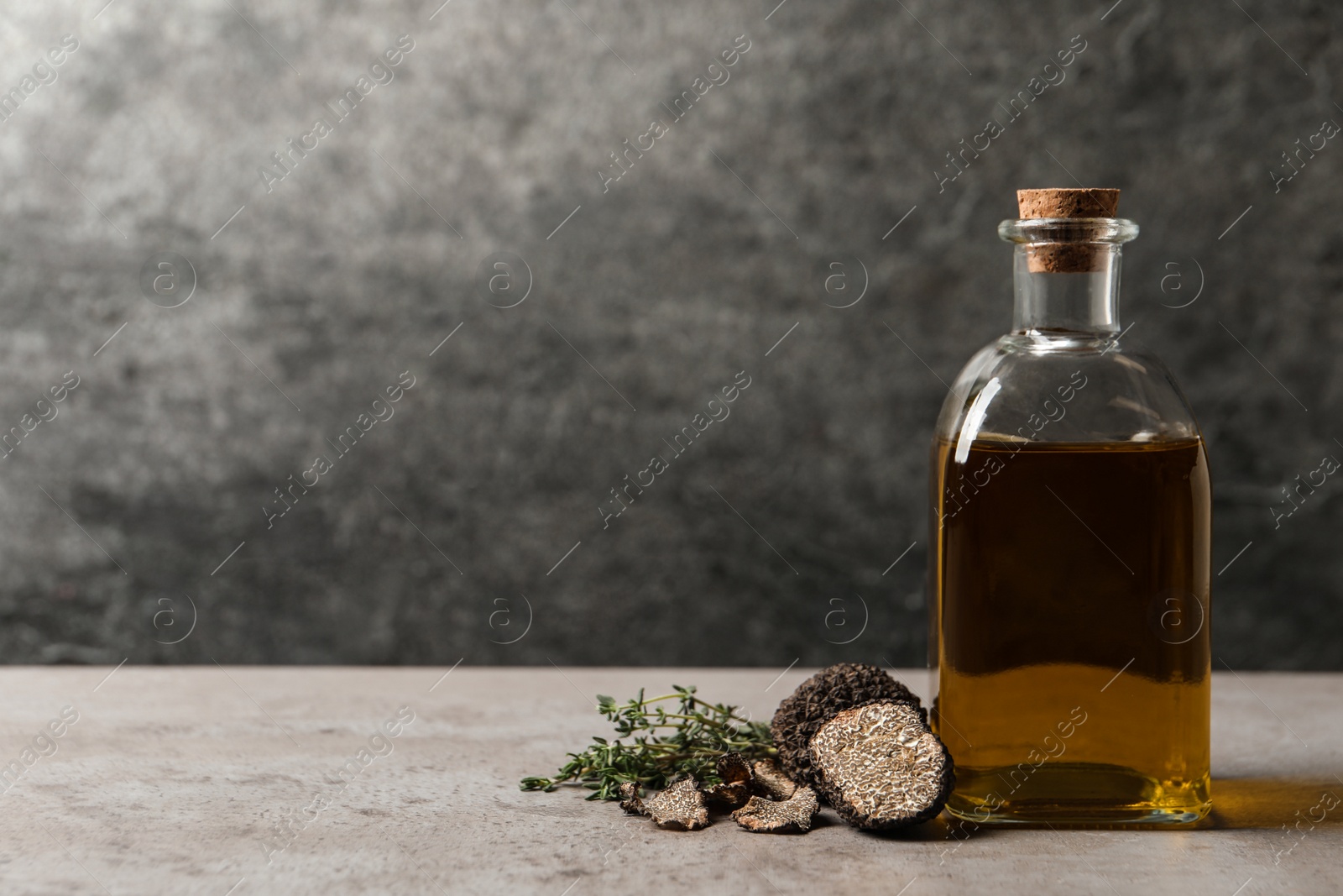 Photo of Fresh truffles, oil and thyme on light grey table, space for text