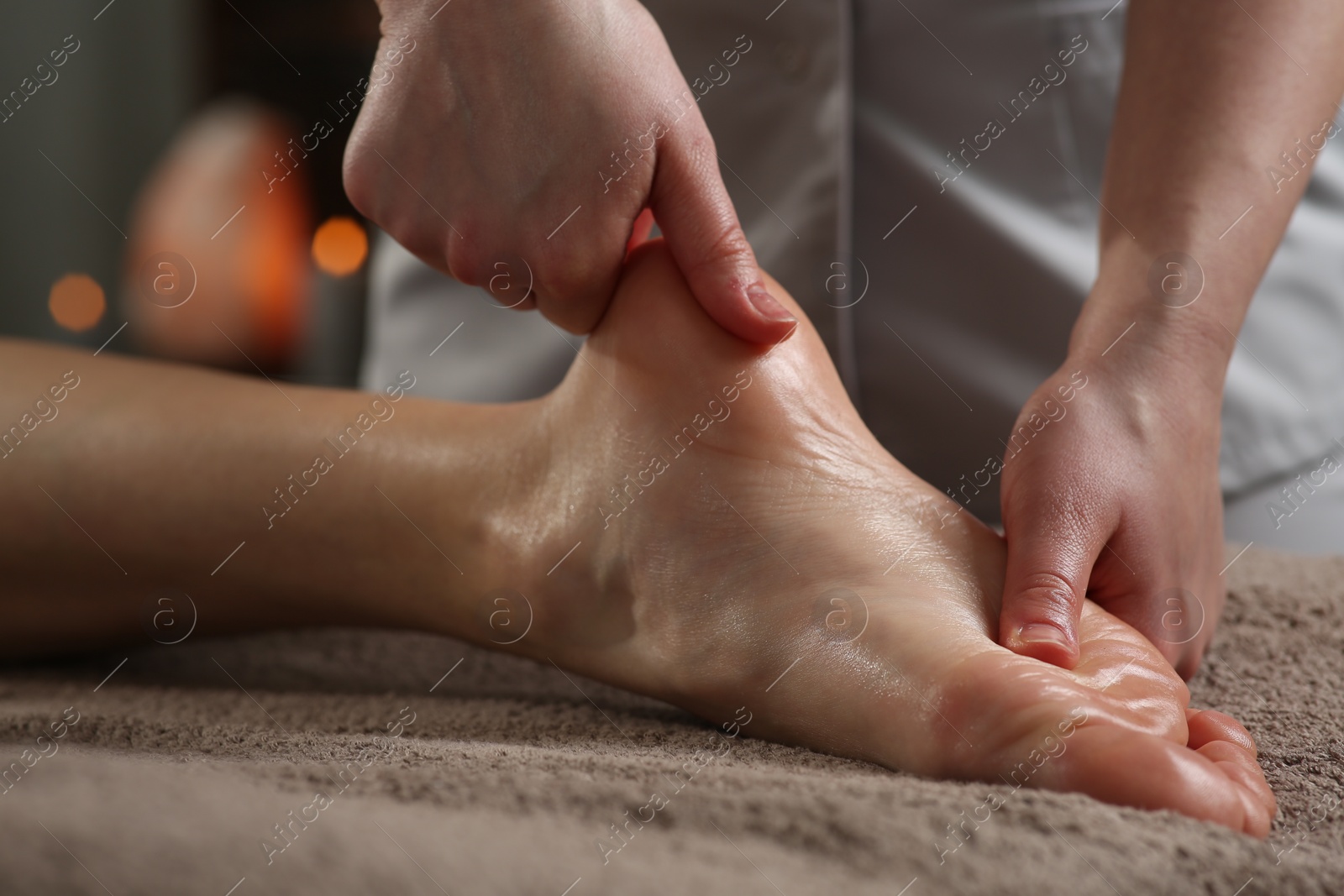 Photo of Woman receiving foot massage in spa salon, closeup