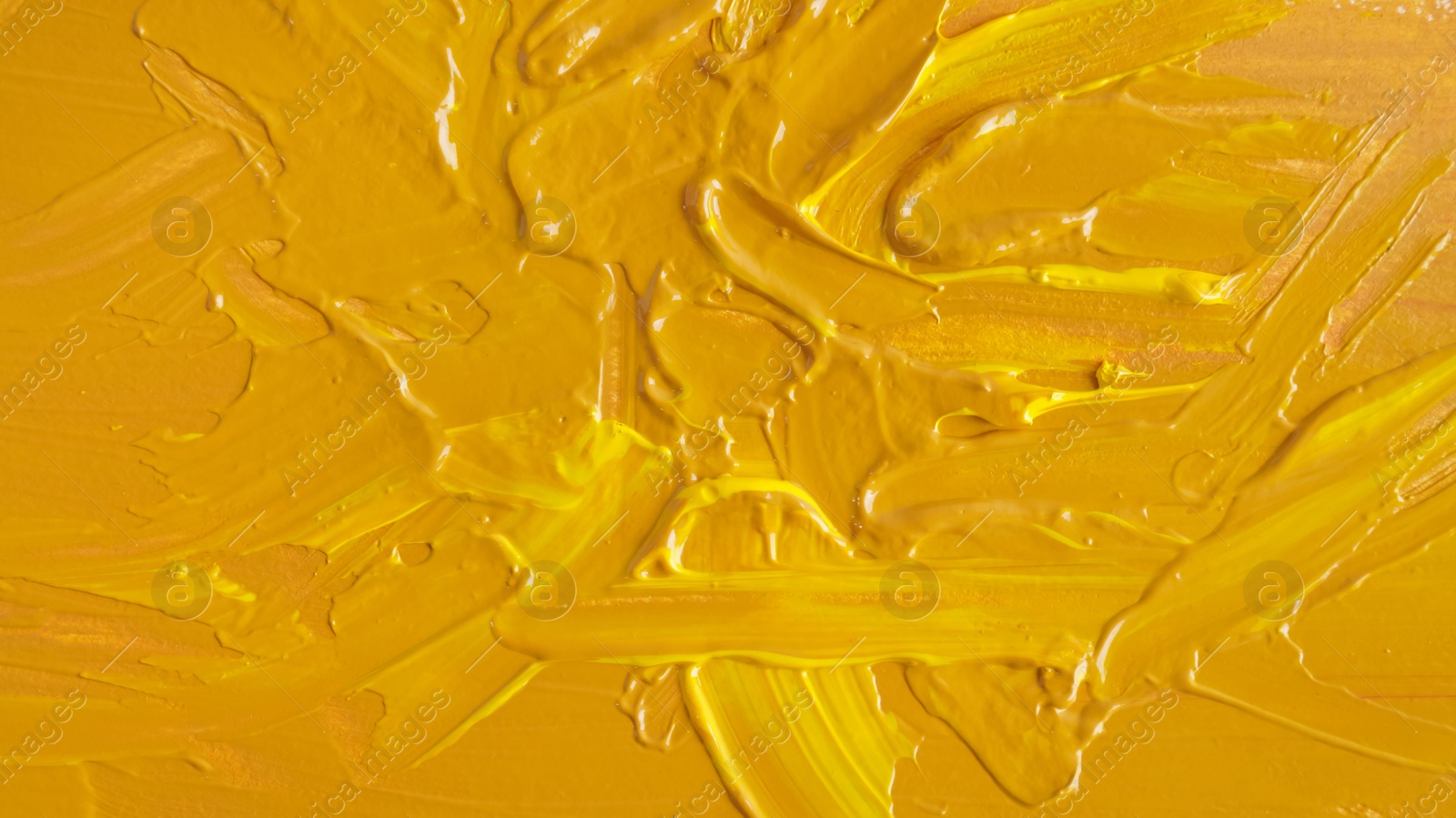 Photo of Yellow paint strokes drawn with brush as background, closeup