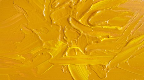 Yellow paint strokes drawn with brush as background, closeup