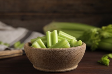 Photo of Cut celery in bowl on wooden table