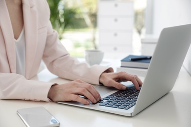 Image of Woman working on laptop at table, closeup