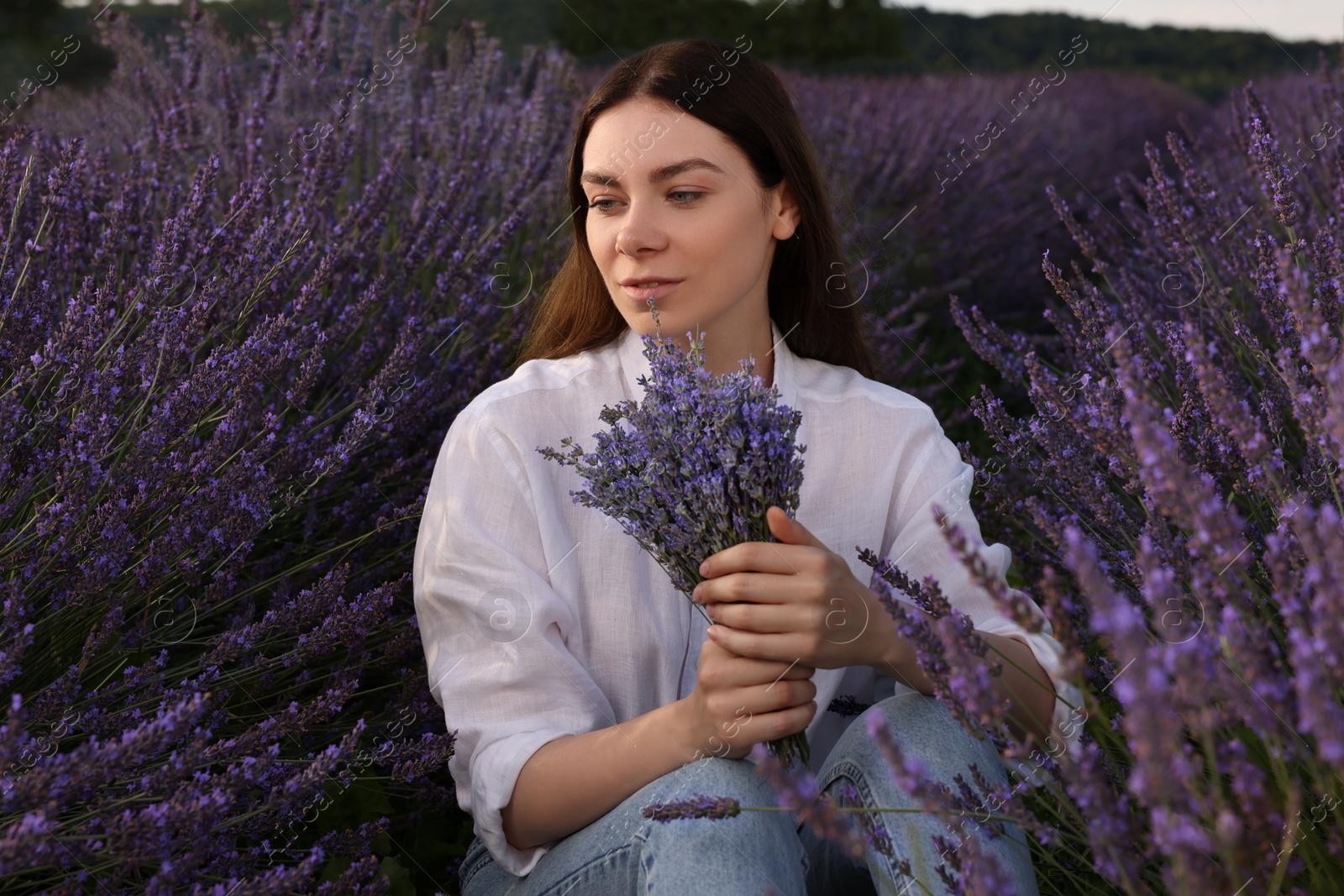 Photo of Beautiful woman with bouquet in lavender field