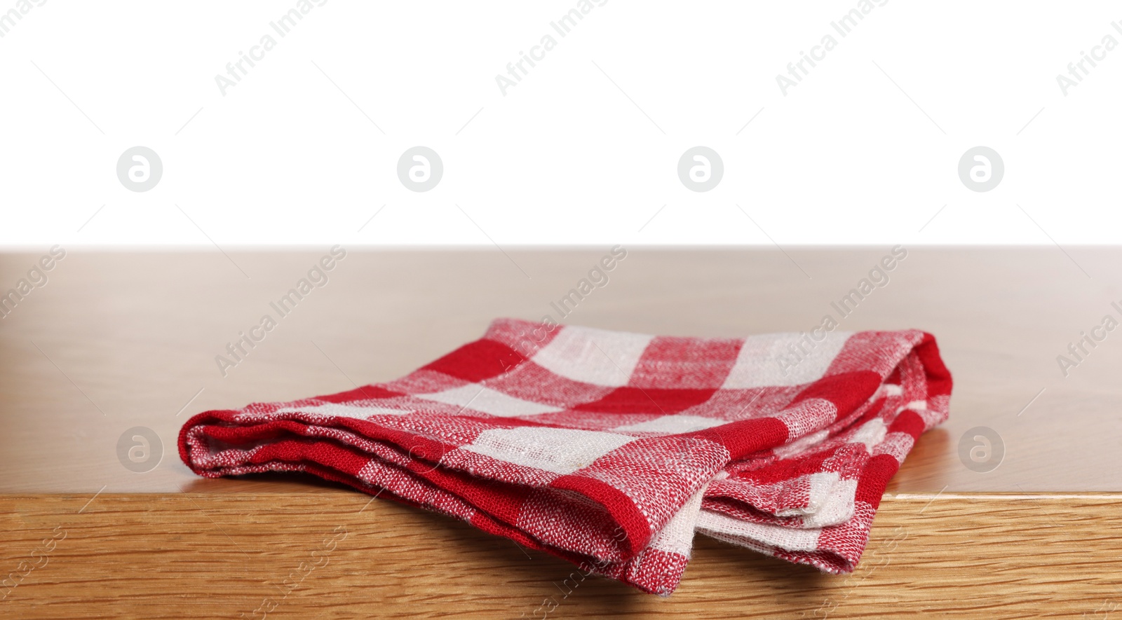 Photo of Checkered tablecloth on wooden table against white background