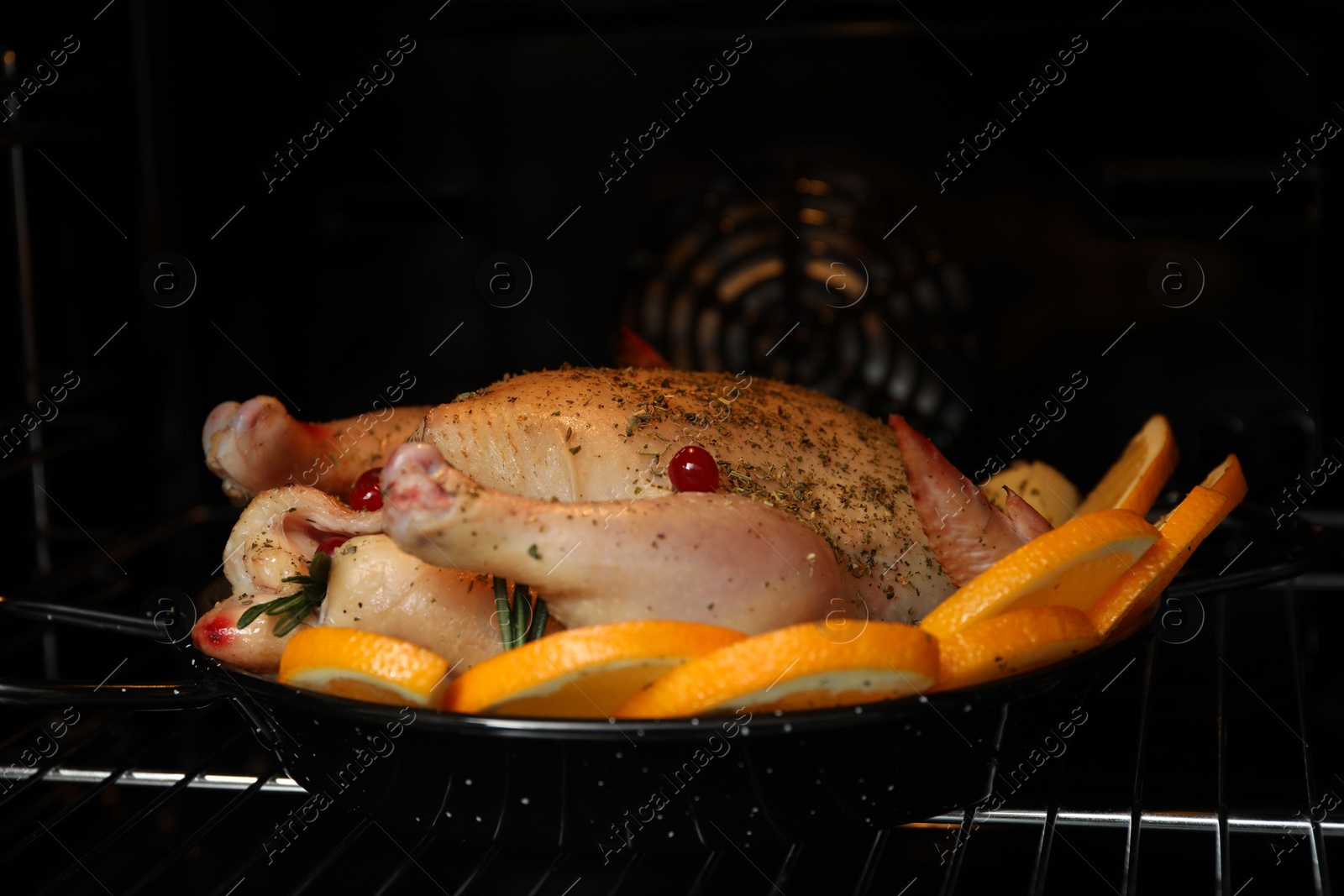 Photo of Chicken with orange slices baking in oven