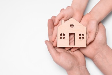 Photo of Home security concept. Family holding house model on white background, top view with space for text