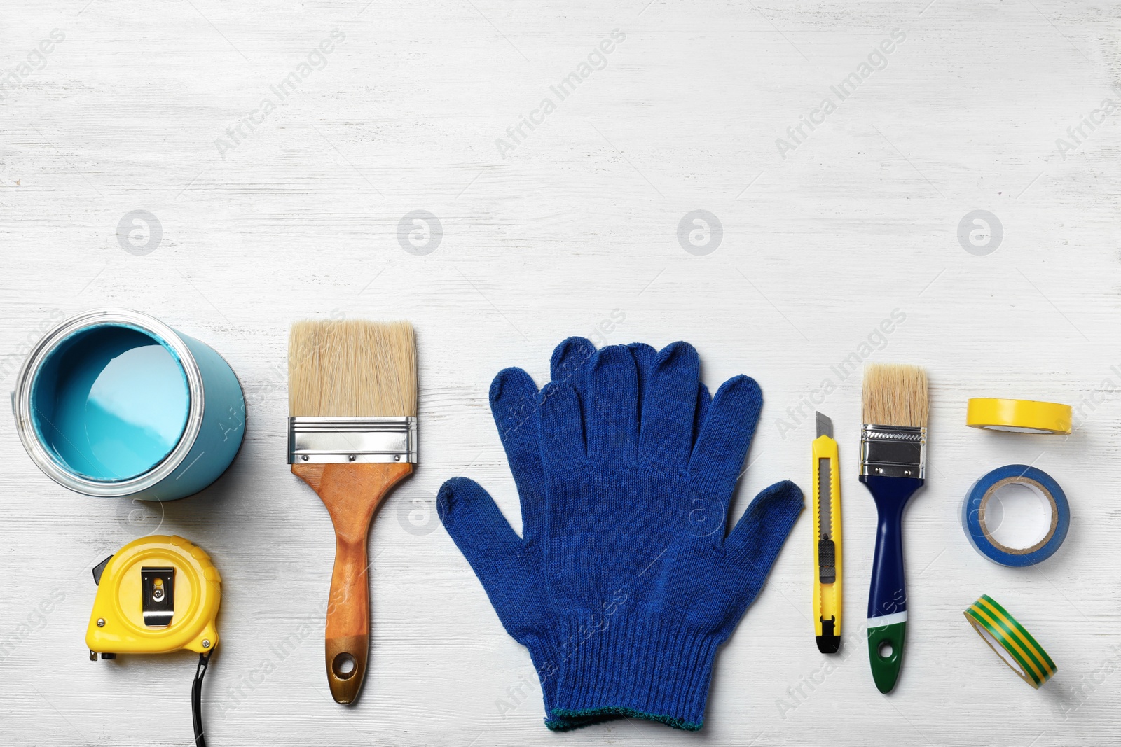 Photo of Set of decorator's tools on wooden background, flat lay