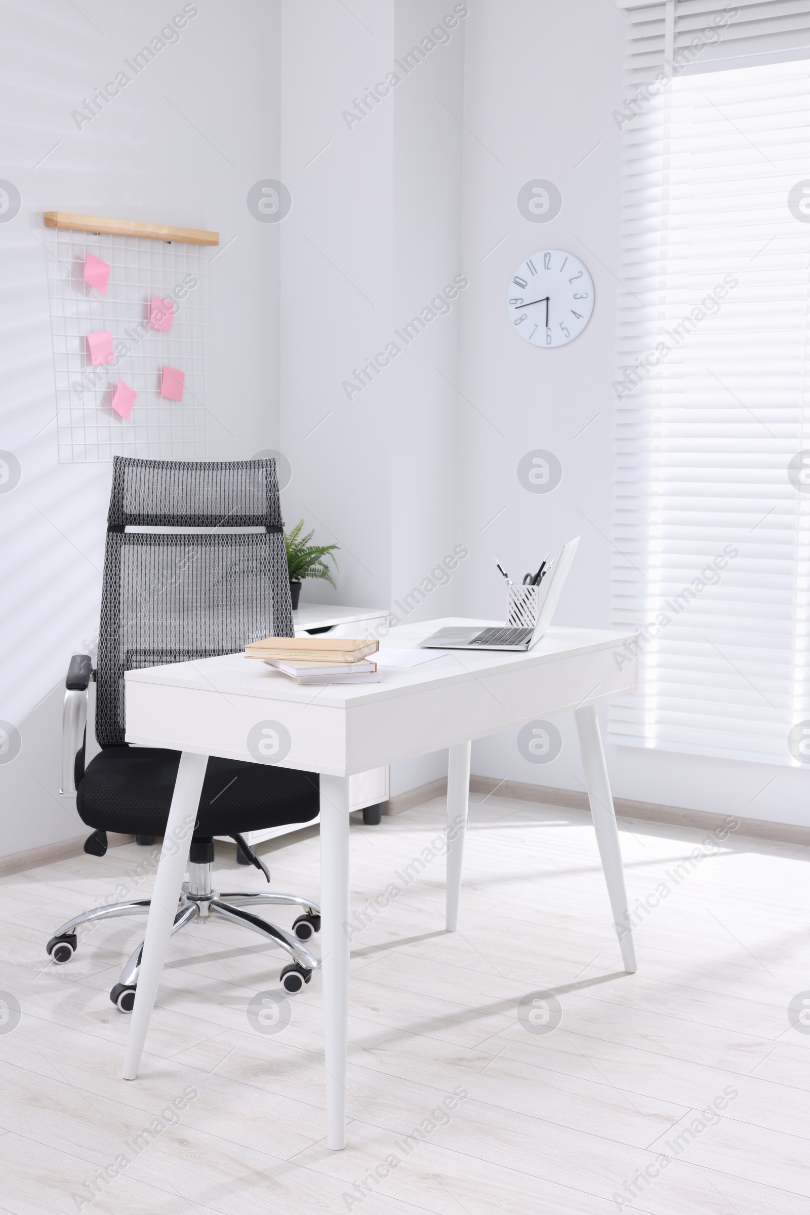 Photo of Desk and comfortable chair in modern office. Interior design