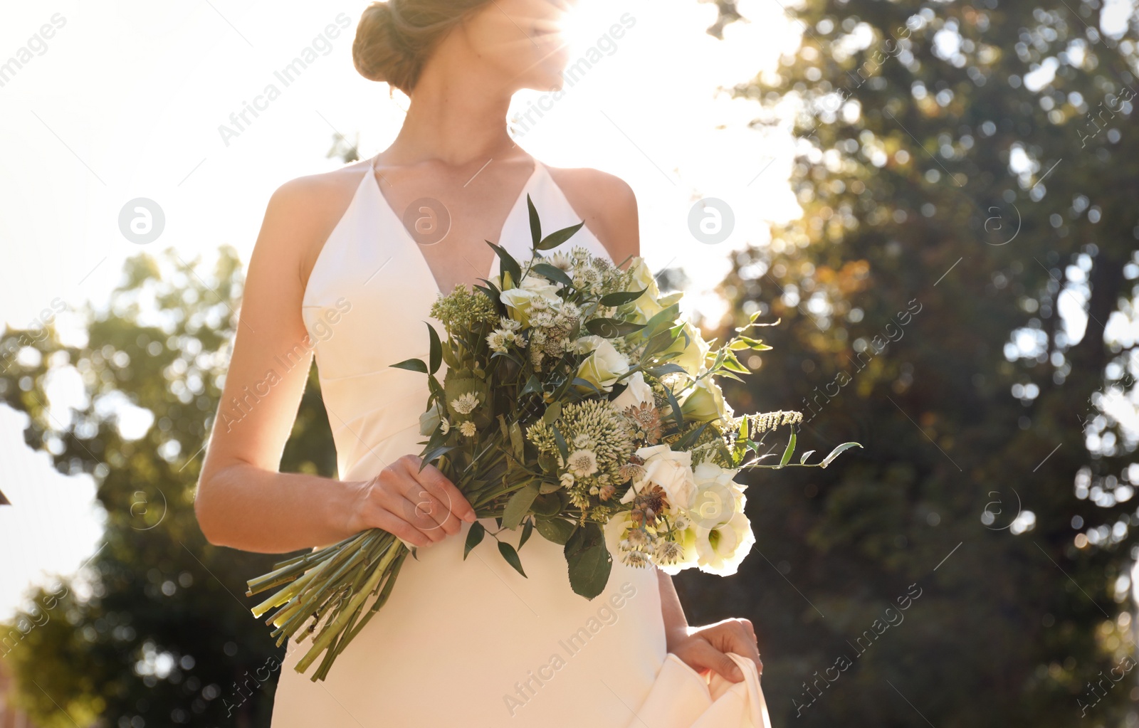 Photo of Bride in beautiful wedding dress with bouquet outdoors, closeup