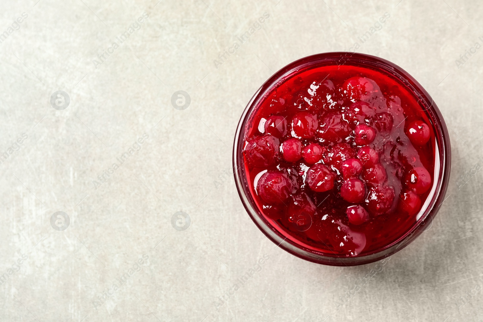 Photo of Cranberry sauce on light table, top view. Space for text