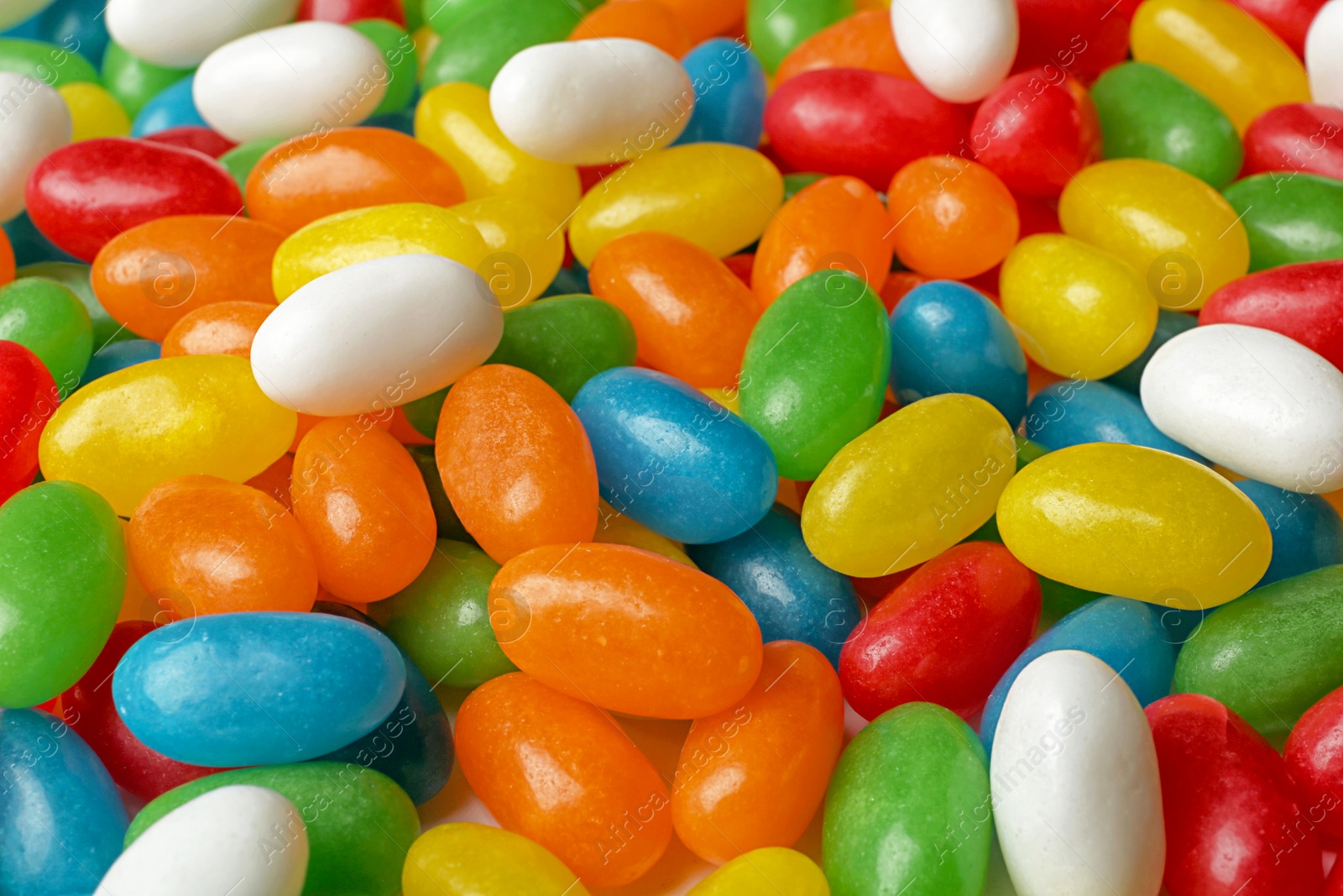 Photo of Tasty bright jelly beans as background, closeup