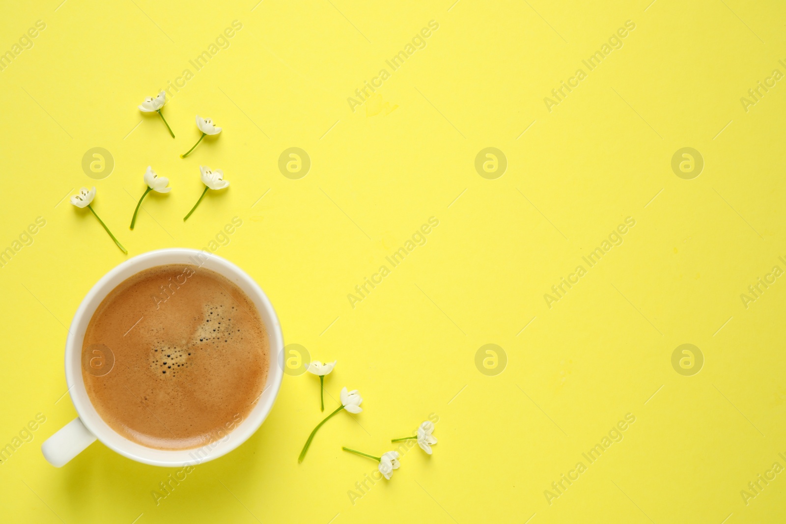 Photo of White flowers and coffee on yellow background, flat lay with space for text. Good morning