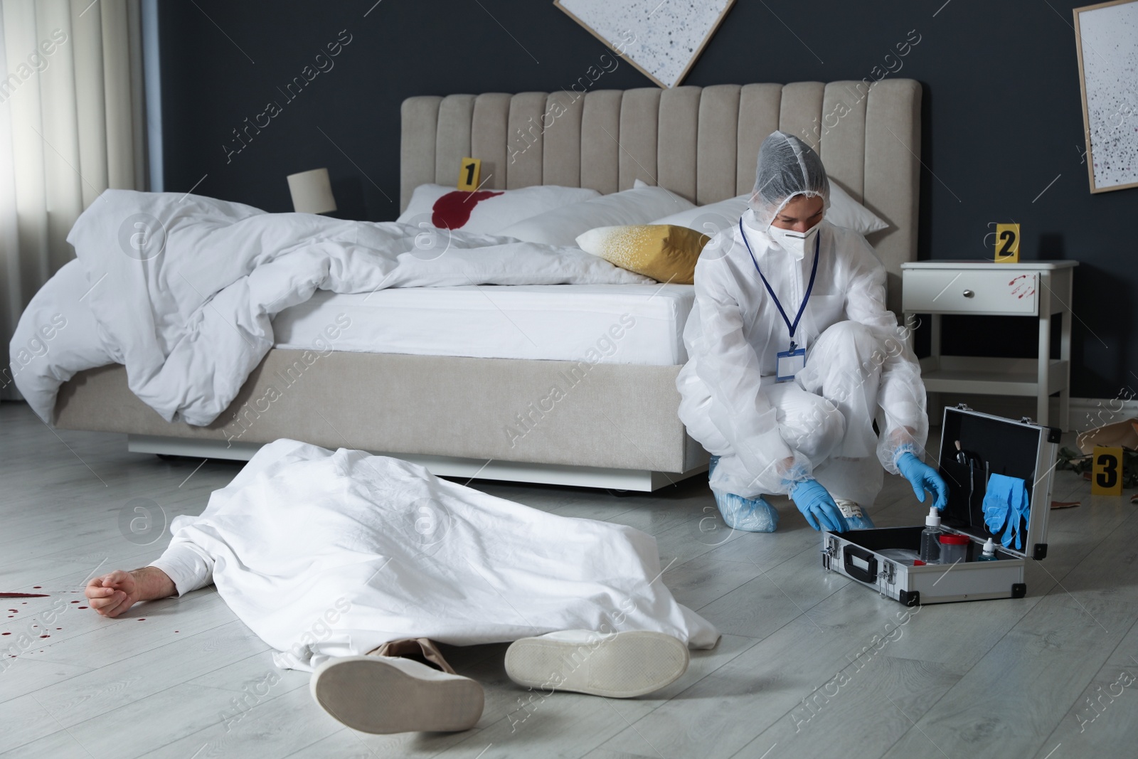 Photo of Investigator in protective suit working at crime scene with dead body