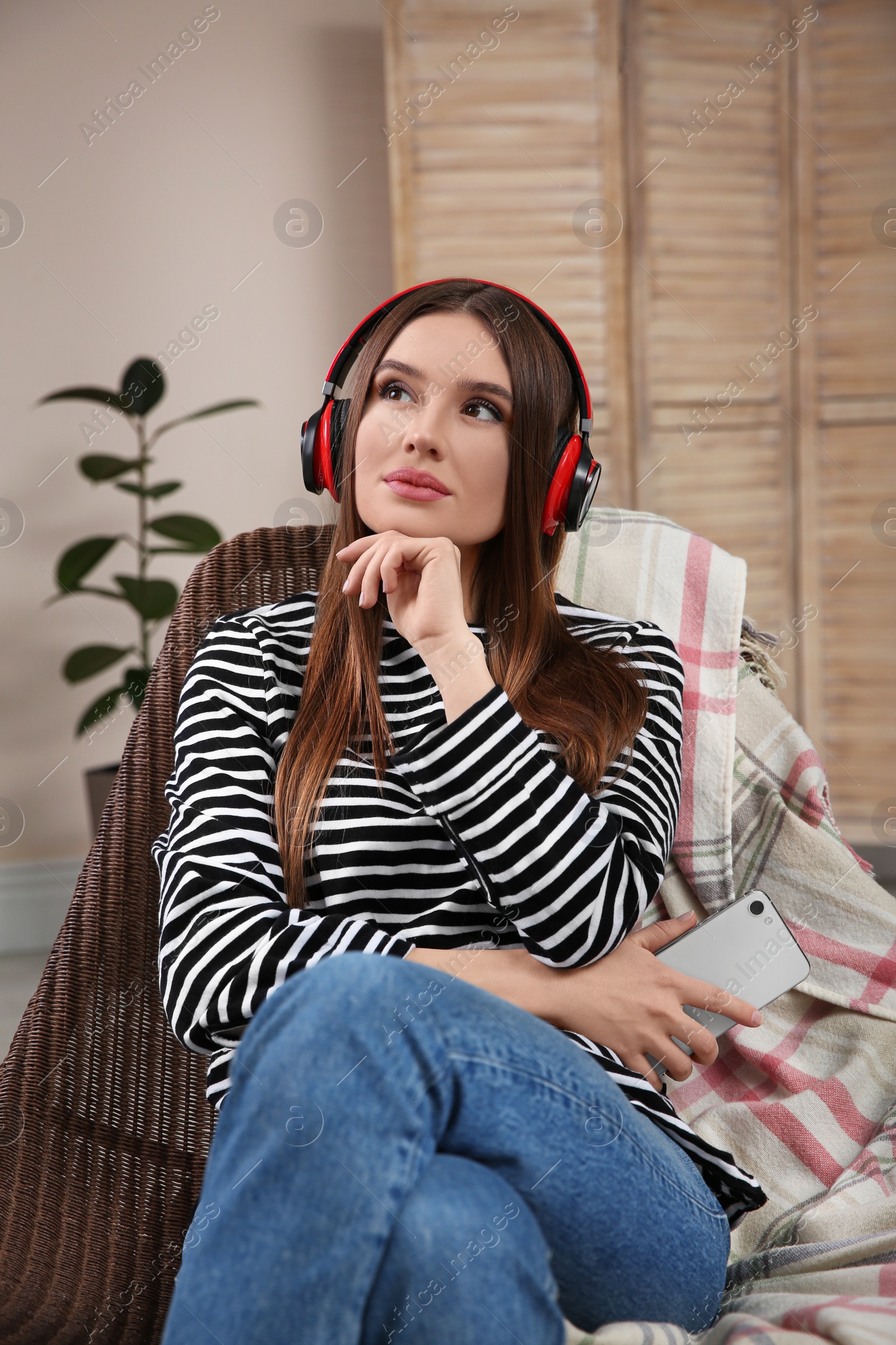 Photo of Woman listening to audiobook in chair at home