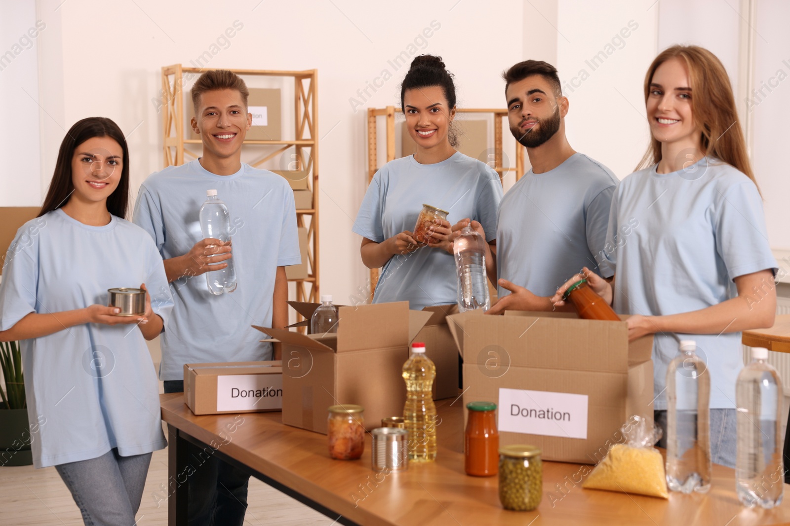 Photo of Portrait of volunteers packing food products in warehouse