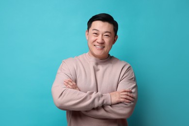 Portrait of happy man on light blue background