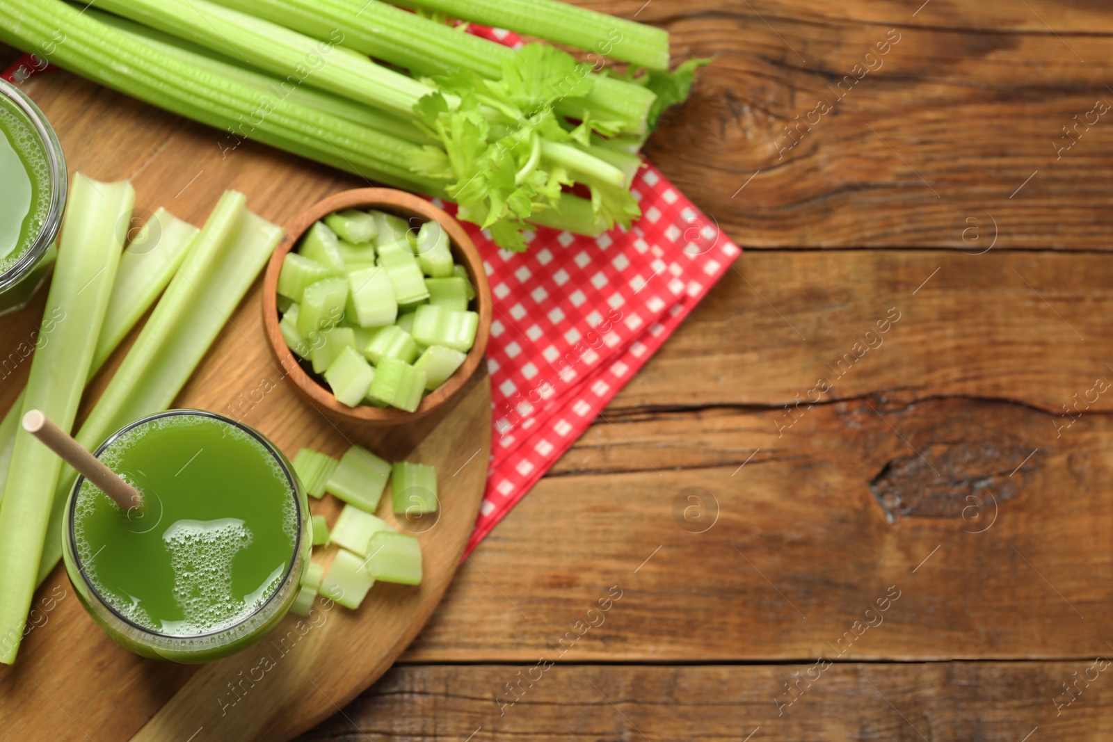 Photo of Glass of delicious celery juice and vegetables on wooden table, flat lay. Space for text