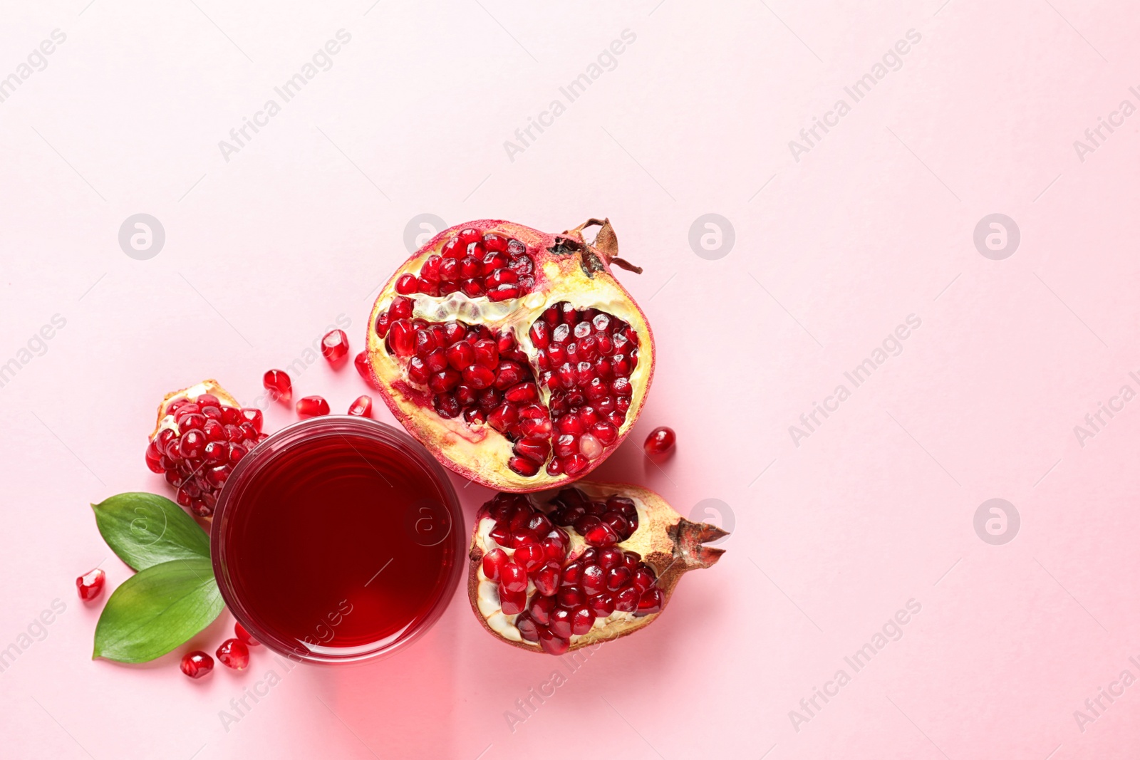 Photo of Glass of pomegranate juice and fresh fruits on color background, top view with space for text