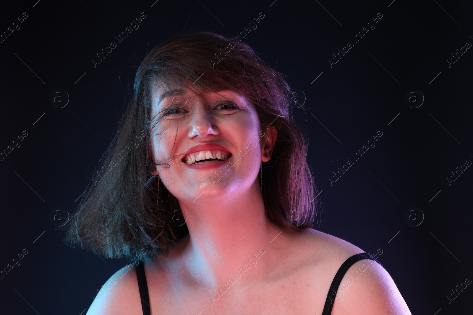 Photo of Portrait of happy woman on dark background