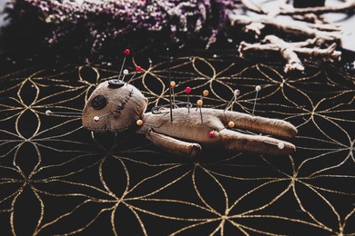 Image of Voodoo doll pierced with pins on table. Curse ceremony