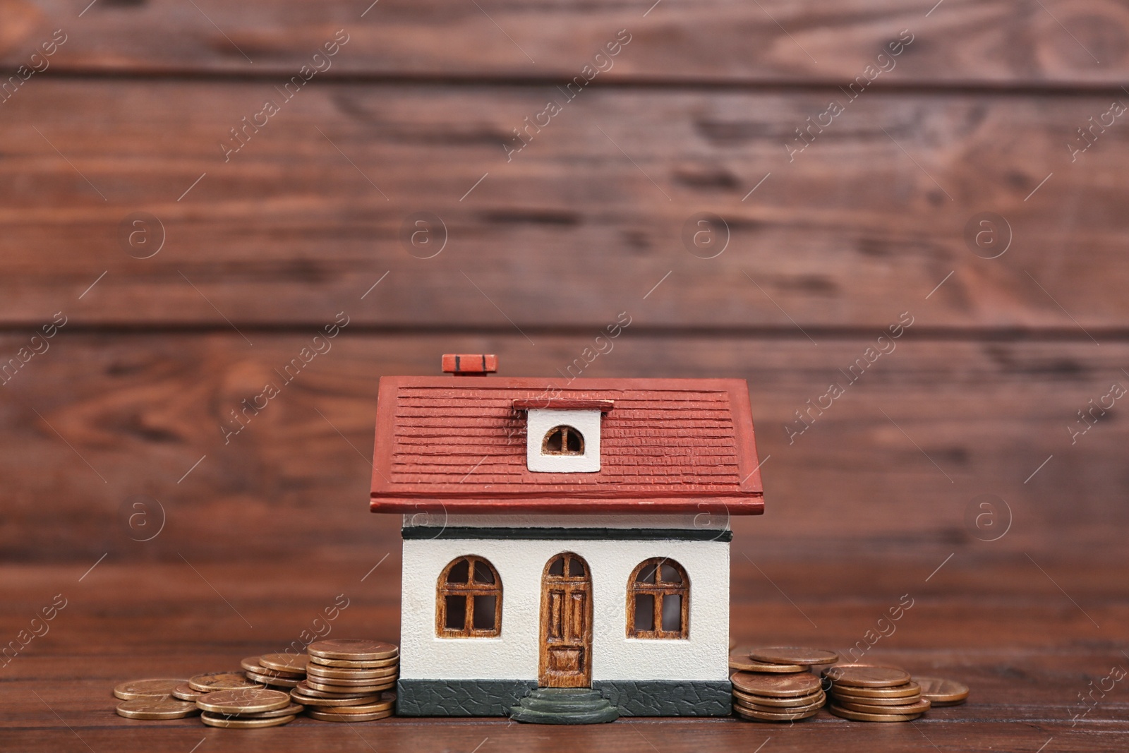Photo of House model and coins on wooden background
