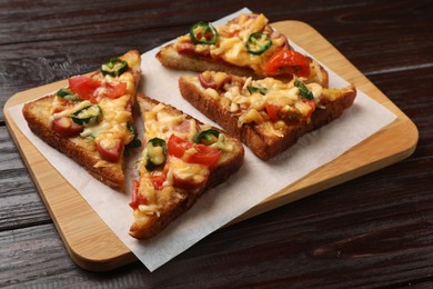 Photo of Tasty pizza toasts served on wooden table