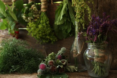 Photo of Bunches of different beautiful dried flowers on wooden table indoors