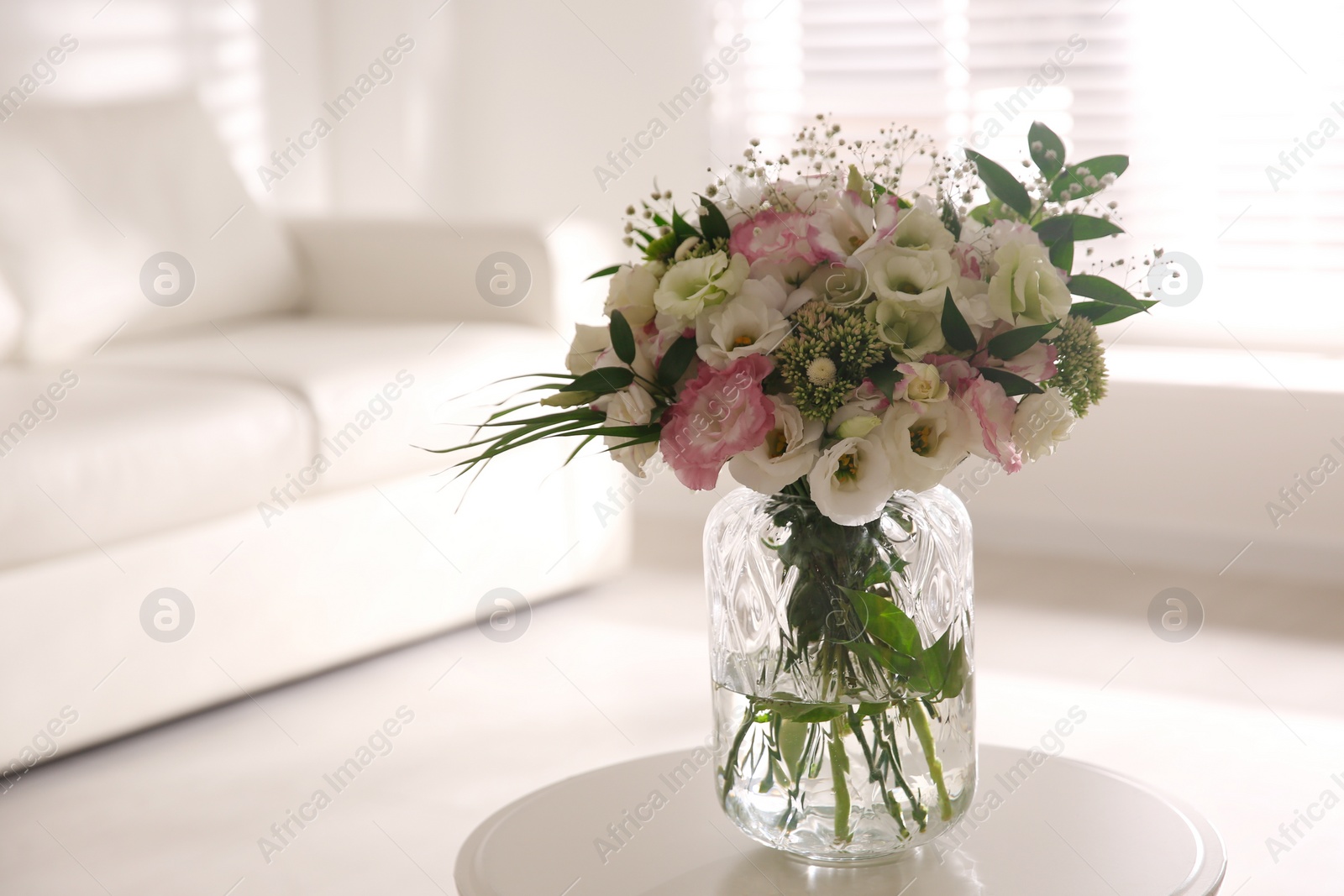 Photo of Bouquet of beautiful flowers on table in living room. Interior design