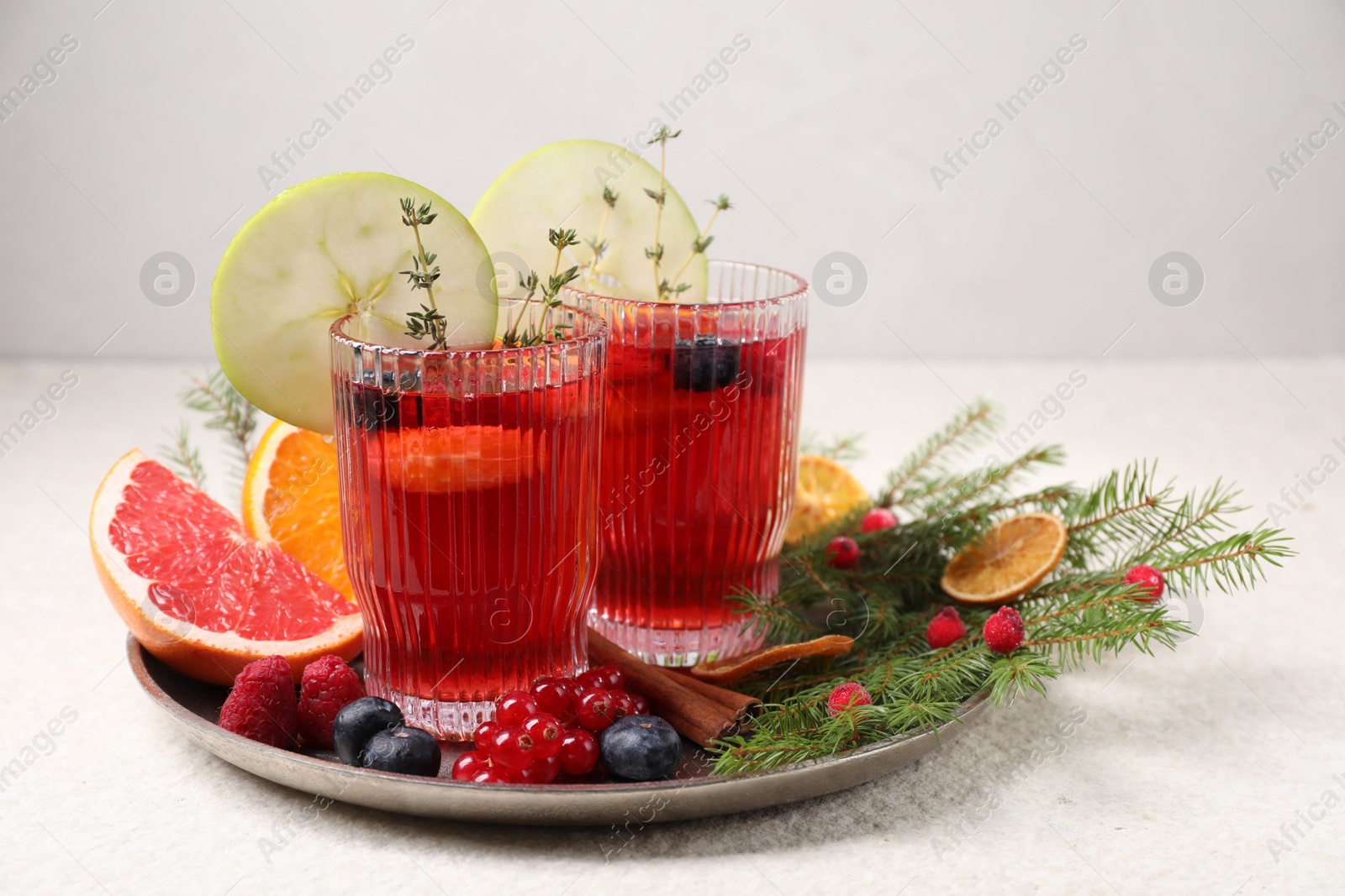 Photo of Aromatic Christmas Sangria in glasses served on light textured table