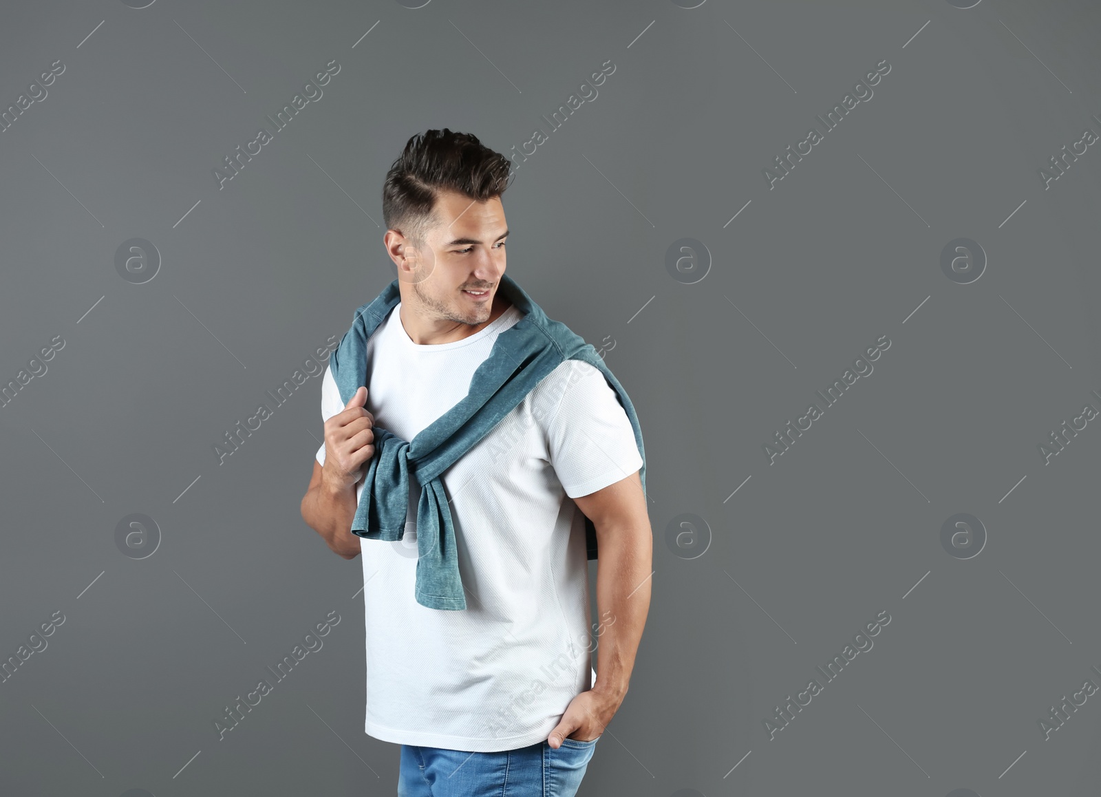 Photo of Young man in stylish jeans on grey background