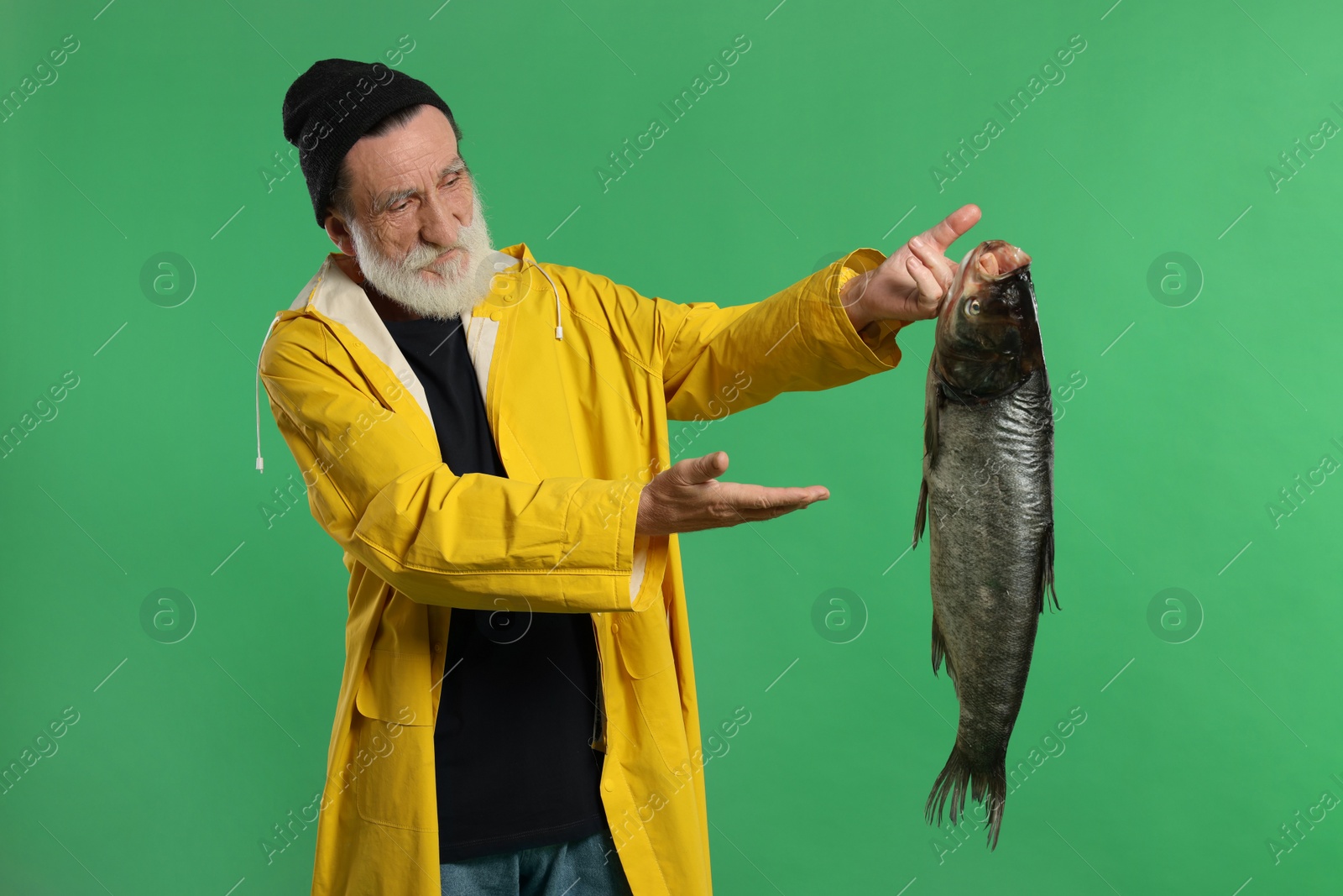 Photo of Fisherman with caught fish on green background