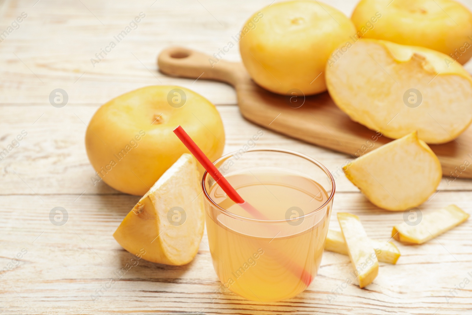 Photo of Glass of freshly made turnip juice on white wooden table