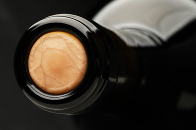 Photo of Closeup view of cork in wine bottle on black background, space for text