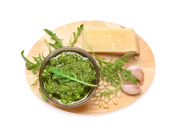 Photo of Bowl of tasty arugula pesto and ingredients on white background, top view