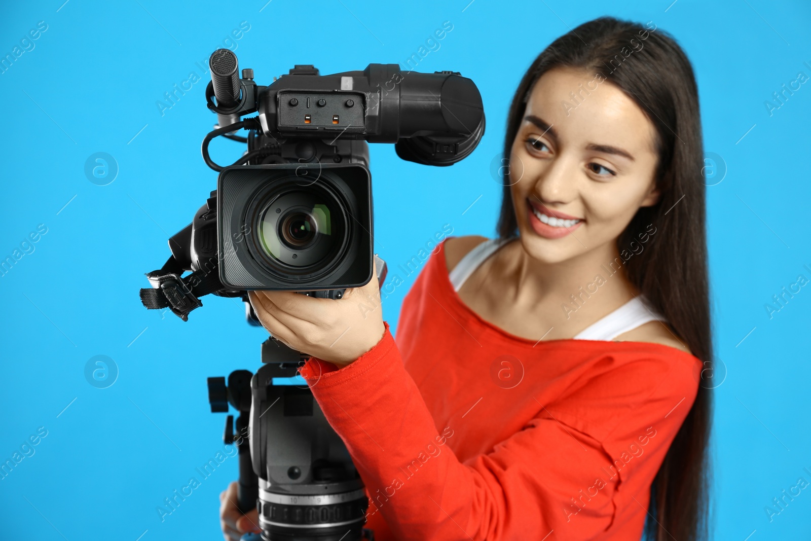 Photo of Operator with professional video camera on blue background