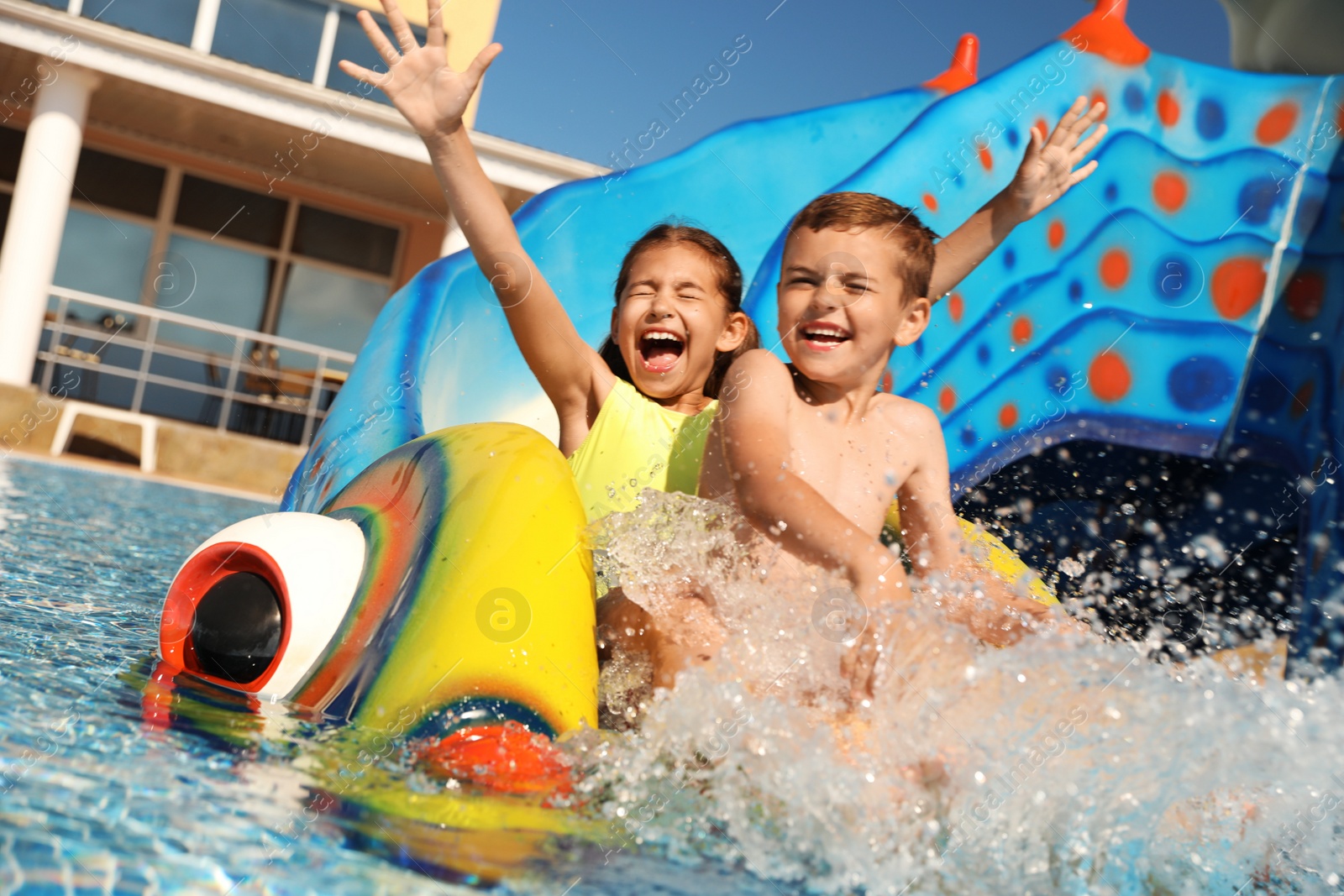 Photo of Happy children on slide at water park. Summer vacation