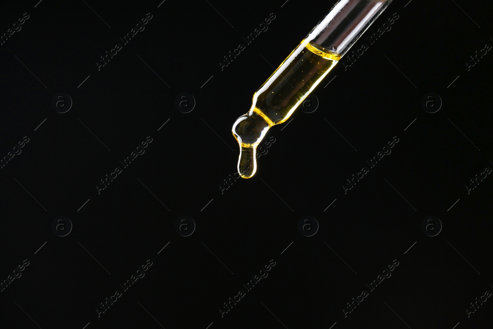 Photo of Dripping tincture from pipette on black background, closeup. Space for text