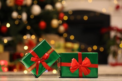 Photo of Beautifully wrapped gift boxes against blurred festive lights. Christmas celebration