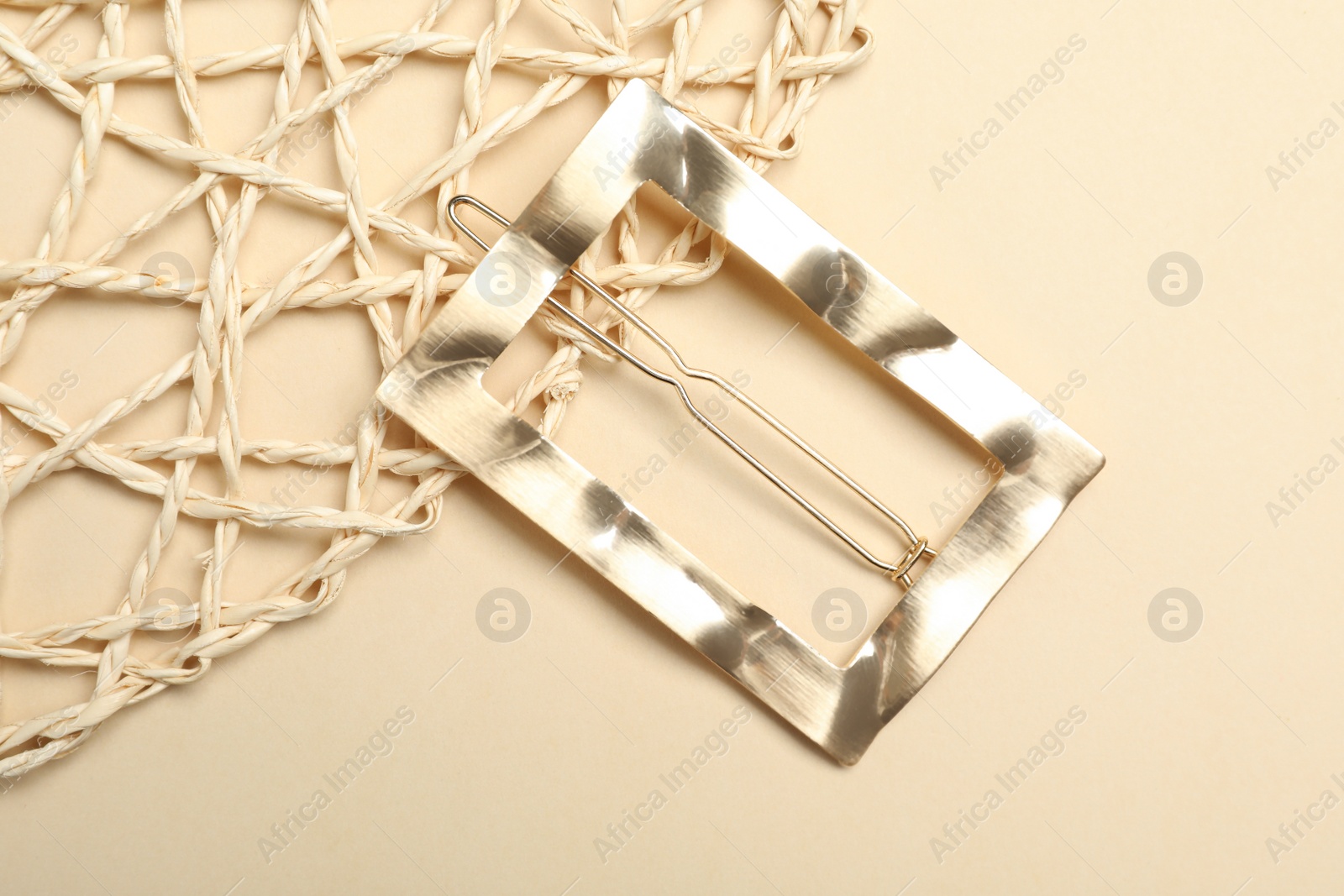 Photo of Stylish hair clip on beige background, top view