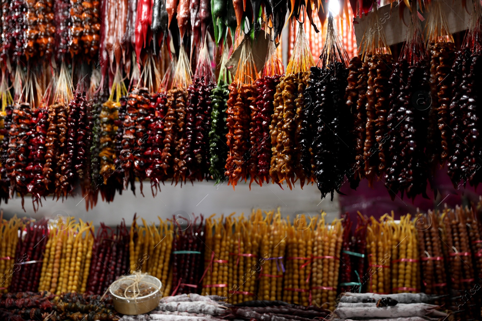 Photo of Bunches of different delicious churchkhelas at market