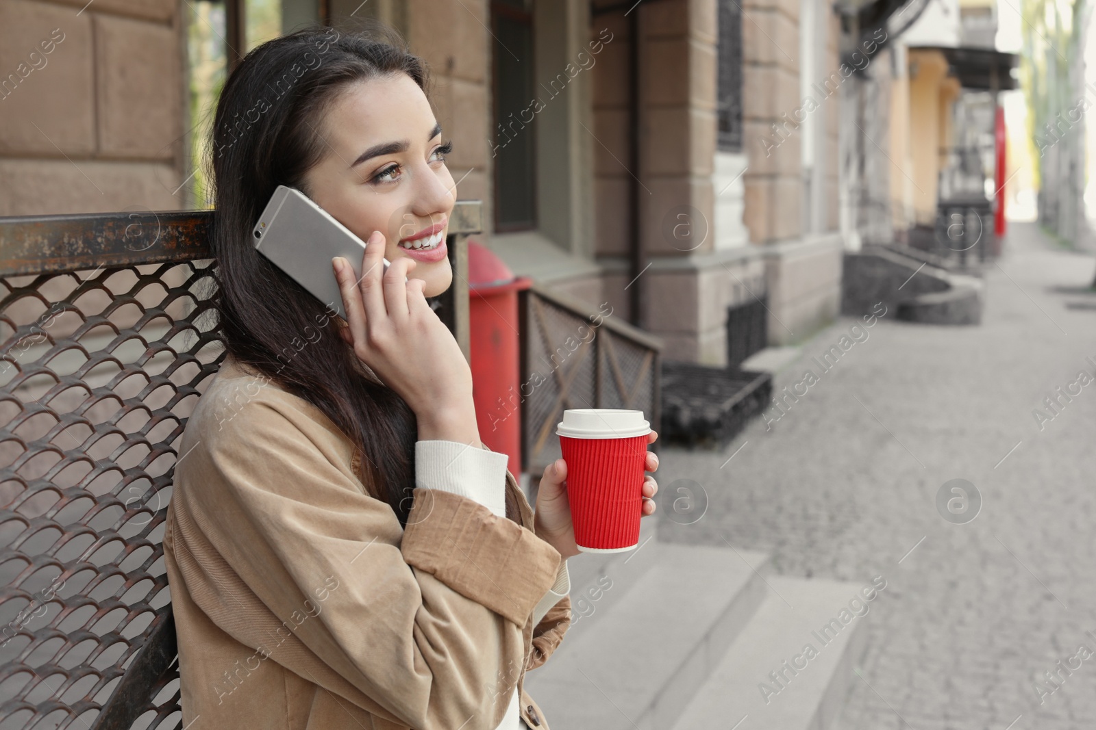 Photo of Young woman talking on mobile phone outdoors