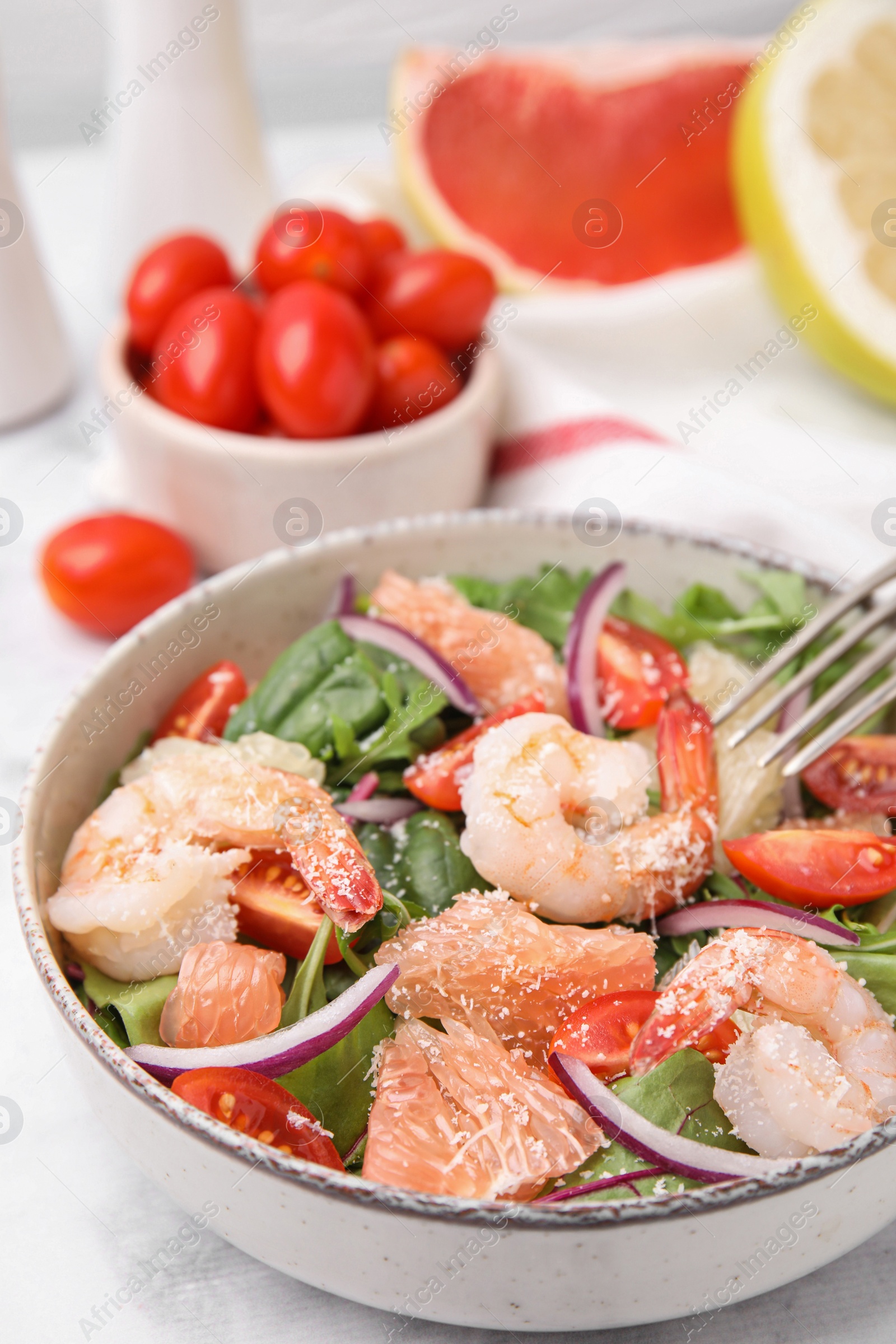 Photo of Delicious pomelo salad with shrimps served on white marble table, closeup
