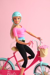 Mykolaiv, Ukraine - September 2, 2023: Beautiful Barbie doll with bicycle on pink background