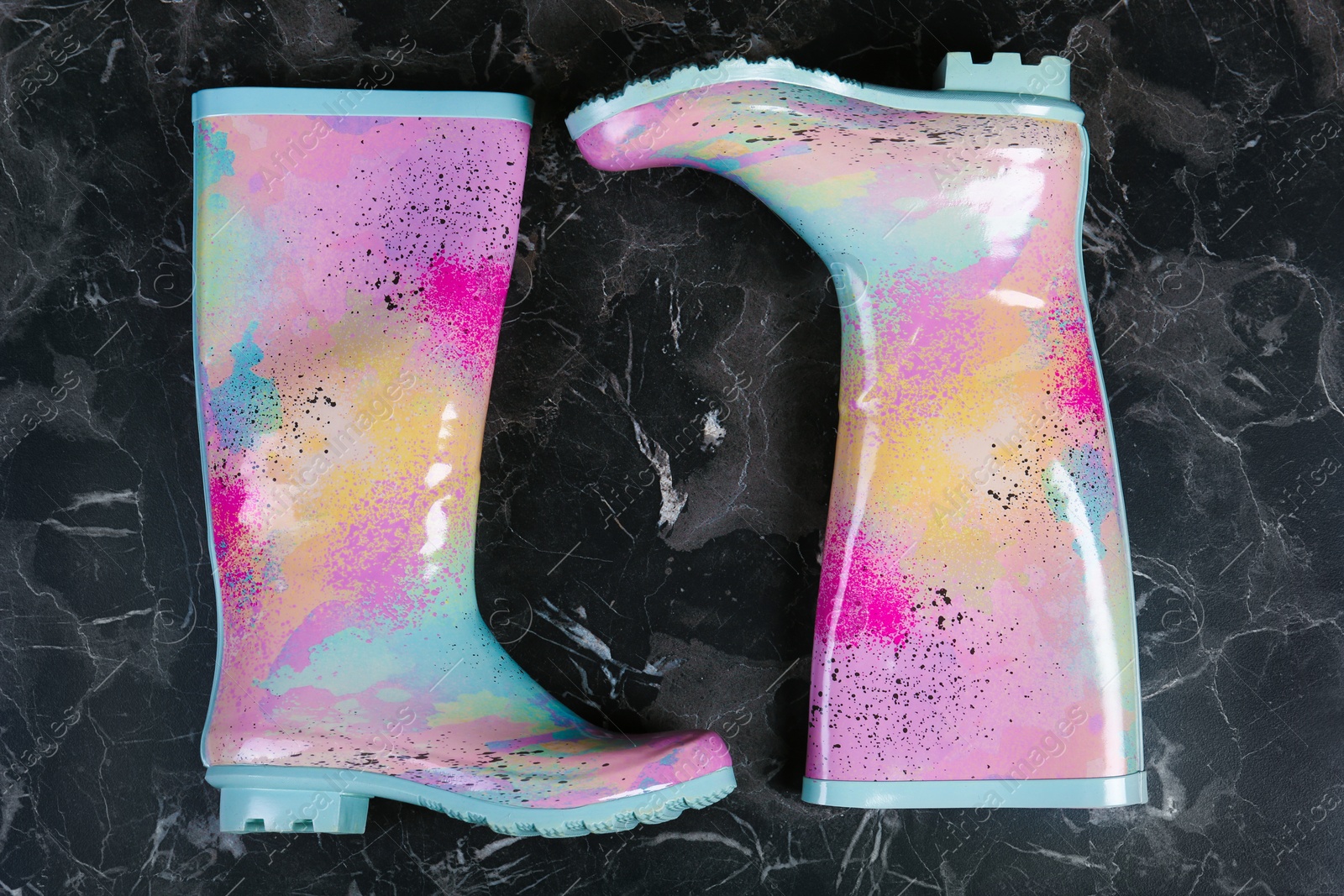 Photo of Pair of gumboots on dark background, top view. Female shoes