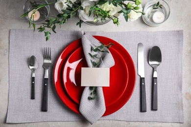 Elegant festive table setting with blank card on grey background, flat lay