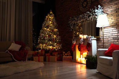 Photo of Stylish room interior with beautiful Christmas tree in evening